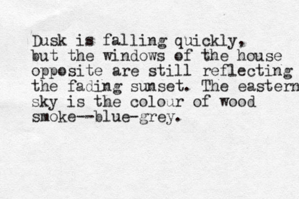Dusk is falling quickly, but the windows of the house opposite are still reflecting the fading sunset. The eastern sky is the colour of wood smoke--blue-grey.
