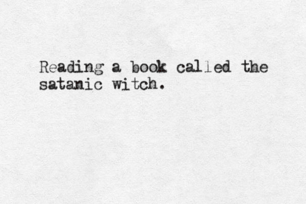 Reading a book called the satanic witch. 