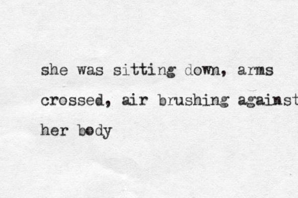she was sitting down, arms crossed, air brushing against her body